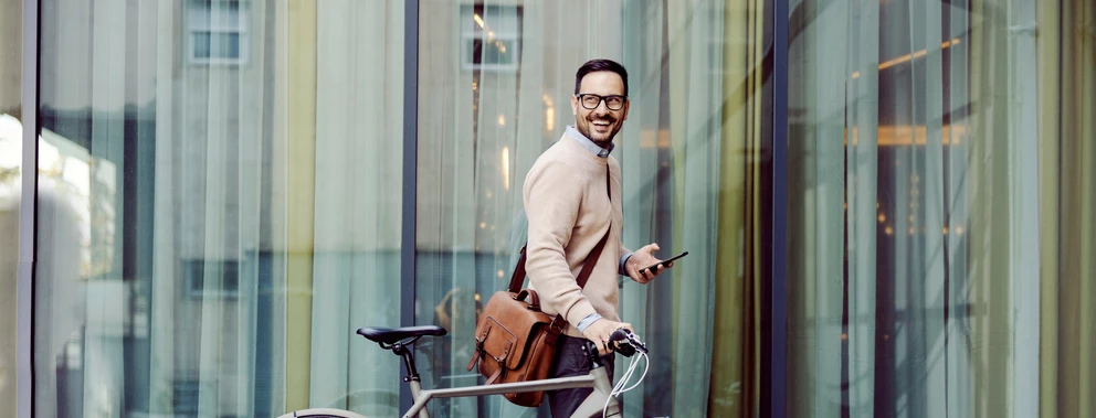 Ein Mann im Anzug fährt Fahrrad und genießt die frische Luft in der Stadt.